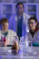 Studenten der Naturwissenschaften mit einem Lehrer bei einem chemischen Reaktionsexperiment im Labor an der Universität. - HPIF03488