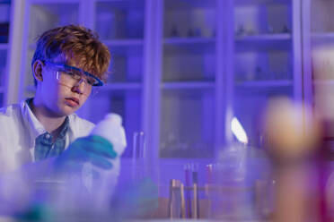Ein Student der Naturwissenschaften macht ein chemisches Experiment im Labor an der Universität. - HPIF03492