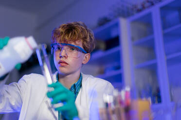 Ein Student der Naturwissenschaften macht ein chemisches Experiment im Labor an der Universität. - HPIF03493
