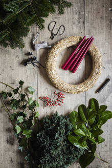 Preparation of Christmas wreath made of spruce, juniper, ivy, rose hips and candles - EVGF04179