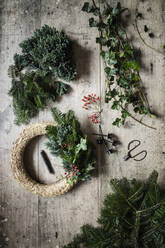 Preparation of Christmas wreath made of spruce, juniper, ivy, and rose hips - EVGF04181