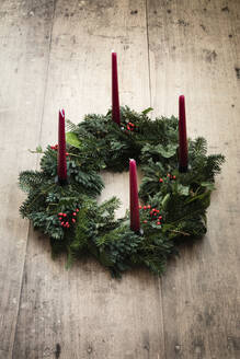 Studio shot of wreath made of spruce, juniper, ivy, rose hips and candles - EVGF04183