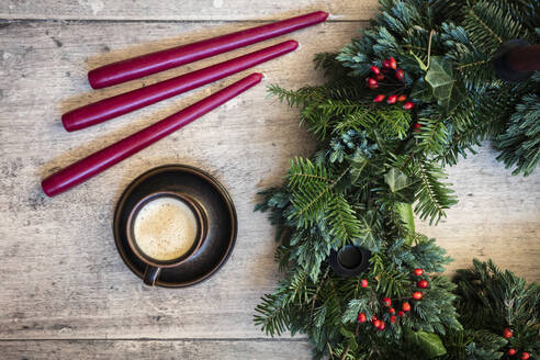 Studio shot of cup of coffee and wreath made of spruce, juniper, ivy and rose hips - EVGF04185