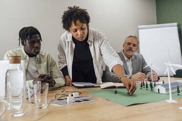 Businesswoman discussing over model on table in office - VPIF07768