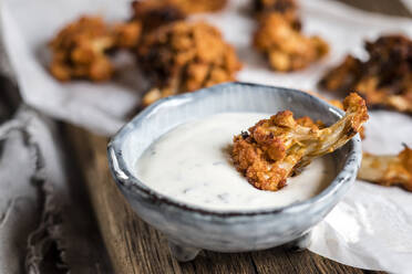 Blumenkohlflügel mit Barbecue-Sauce auf dem Schneidebrett - SBDF04576