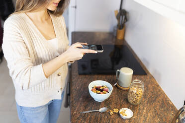 Young woman photographing breakfast through smart phone - JPTF01164