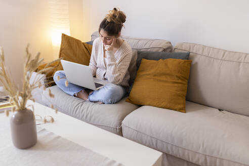 Junge Frau benutzt Laptop zu Hause - JPTF01172