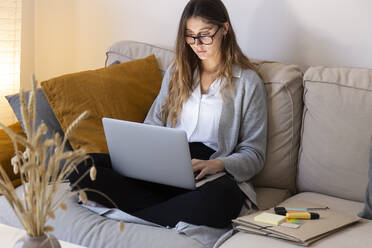 Junge Frau studiert zu Hause am Laptop - JPTF01181