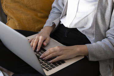 Young woman using laptop at home - JPTF01183