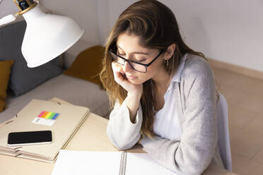 Young woman with book studying at home - JPTF01185