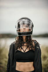 Woman wearing helmet smoking cigarette - MJRF00816