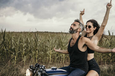 Carefree mature man and woman riding motorcycle - MJRF00831