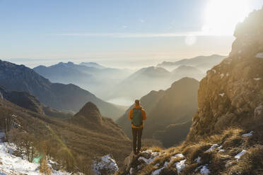 Hiker with backpack standing on mountain - MCVF01023