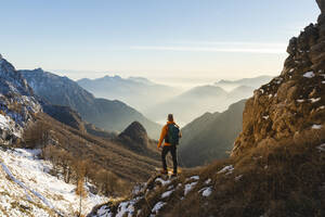 Mature hiker standing in front of mountains - MCVF01029