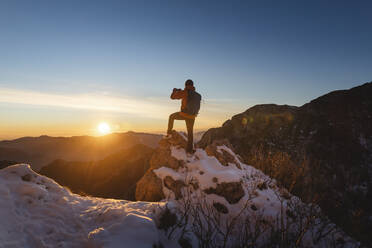 Wanderer fotografiert bei Sonnenaufgang mit dem Smartphone - MCVF01031