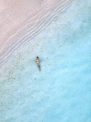 Frau schwimmt im blauen Meer am Strand - KNTF06854