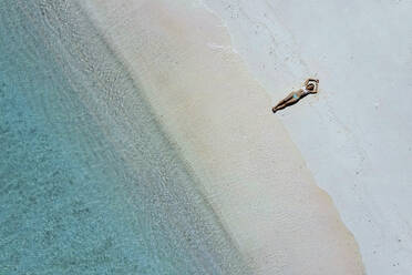 Woman lying at beach on sunny day - KNTF06857