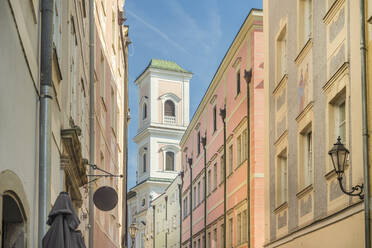 Deutschland, Bayern, Passau, Wohnhäuser entlang der Schustergasse mit dem Glockenturm der St. Michaelskirche im Hintergrund - TAMF03732