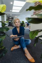 Thoughtful businesswoman holding tablet PC in workplace - JOSEF15226