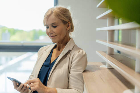 Reife Geschäftsfrau mit Smartphone im Büro - JOSEF15272