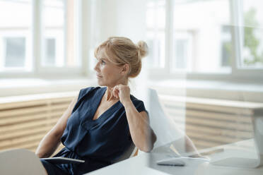 Contemplative mature businesswoman with tablet PC at office - JOSEF15291