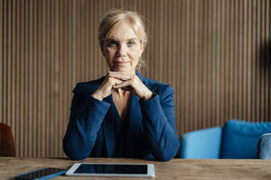 Mature businesswoman with tablet PC and mobile phone at desk - JOSEF15347