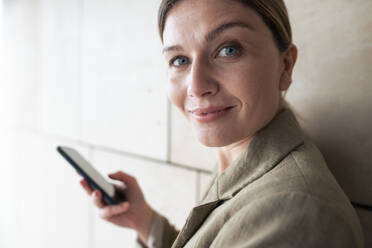 Smiling businesswoman with smart phone - JOSEF15500