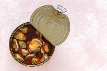Draufsicht auf appetitliche Muscheln in einer offenen Dose mit Soße auf dem Tisch - ADSF42025