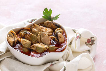 From above ceramic plate with yummy mussels in sauce standing on piece of cloth on gray background - ADSF42027