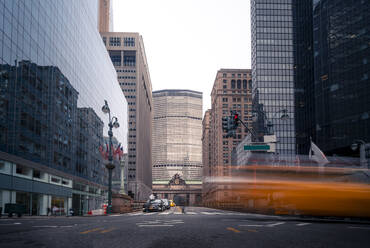 Autos fahren auf der Straße in der Nähe von Hochhäusern gegen wolkenlosen blauen Himmel an einem sonnigen Tag in Manhattan, New York, USA - ADSF42075