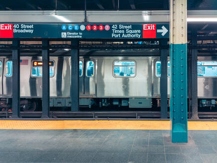 Grauer Metallzug in der Nähe des Bahnsteigs und Schilder auf einer U-Bahn-Station in New York, USA - ADSF42081