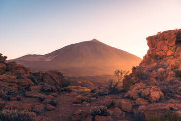 Malerische Landschaft mit vulkanischen Feldern, die zu felsigen Bergen führen, vor bedecktem Himmel auf Teneriffa - ADSF42085