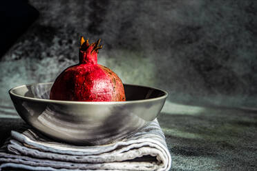 Ripe organic pomegranate fruit on the ceramic bowl and tea towel - ADSF42121