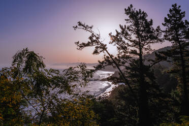 Breathtaking view of sea water waving near Alkolea Beach covered with lush plants against sundown sky in Mutriku, Gipuzkoa, Spain - ADSF42138