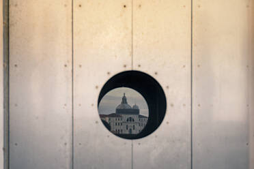 Atemberaubender Blick auf die Kirche Santa Maria della Salute durch ein rundes Loch in der Wand am Abend in Venedig, Italien - ADSF42146