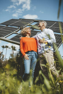 Glückliches reifes Paar steht vor Sonnenkollektoren im Garten - JOSEF15578
