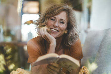 Smiling mature woman reading book - JOSEF15645