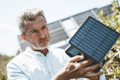Mann, der an einem sonnigen Tag die Ausrüstung für Sonnenkollektoren untersucht - JOSEF15672