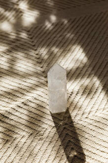 Heilkristall auf Teppich im Sonnenlicht - MEGF00338