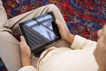 Älterer Mann beobachtet Tablet-PC zu Hause - EYAF02374