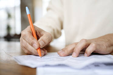 Man writing on bills with pen - EYAF02379