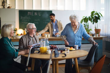 Eine Gruppe fröhlicher Senioren genießt das Frühstück in einem Pflegeheim. - HPIF03596