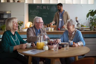 Eine Gruppe fröhlicher Senioren genießt das Frühstück in einem Pflegeheim. - HPIF03605