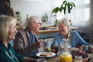Eine Gruppe fröhlicher Senioren genießt das Frühstück in einem Pflegeheim. - HPIF03608