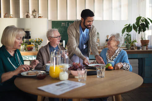 Eine Gruppe fröhlicher Senioren genießt das Frühstück in einem Pflegeheim. - HPIF03610