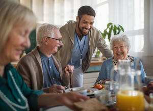 Eine Gruppe fröhlicher Senioren genießt das Frühstück in einem Pflegeheim. - HPIF03611