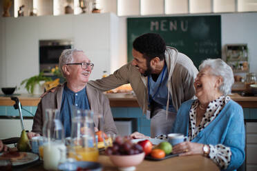 Eine Gruppe fröhlicher Senioren genießt das Frühstück in einem Pflegeheim. - HPIF03622