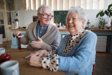 Eine lächelnde ältere Frau und ein Mann genießen das Frühstück in einem Pflegeheim. - HPIF03634
