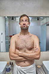 Nachdenklicher Mann mit Jadewalze im Mund im Badezimmer - VEGF06089