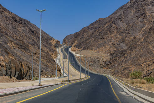 Saudi Arabia, Najran Province, Najran, Asphalt road in rocky mountains - RUNF04750